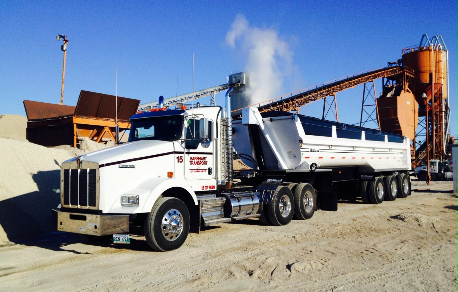 Barnhart Transport Kenworth truck with side-dump trailer at an aggregate processing facility